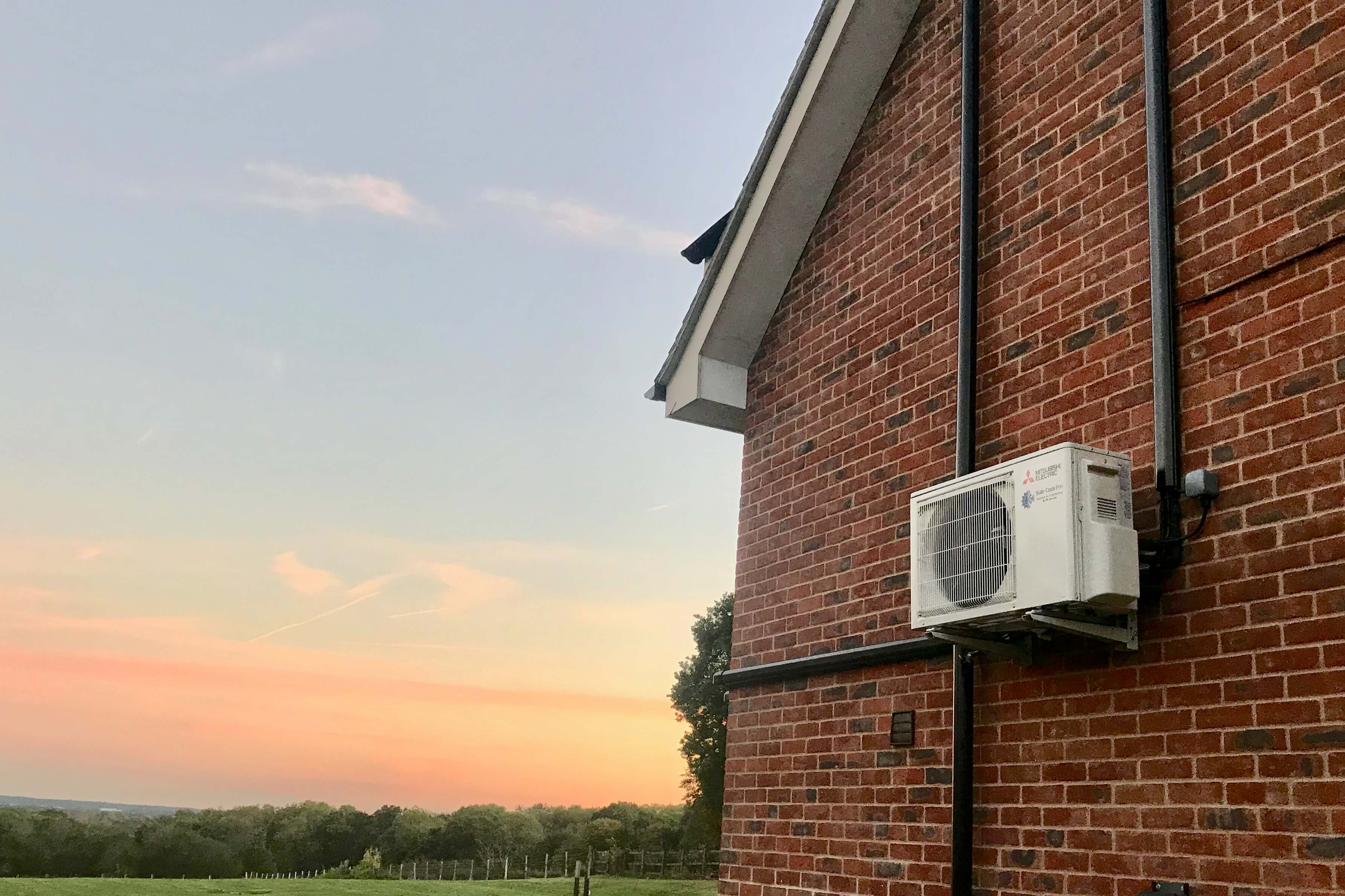 An air conditioning unit fixed to an outside wall of a home