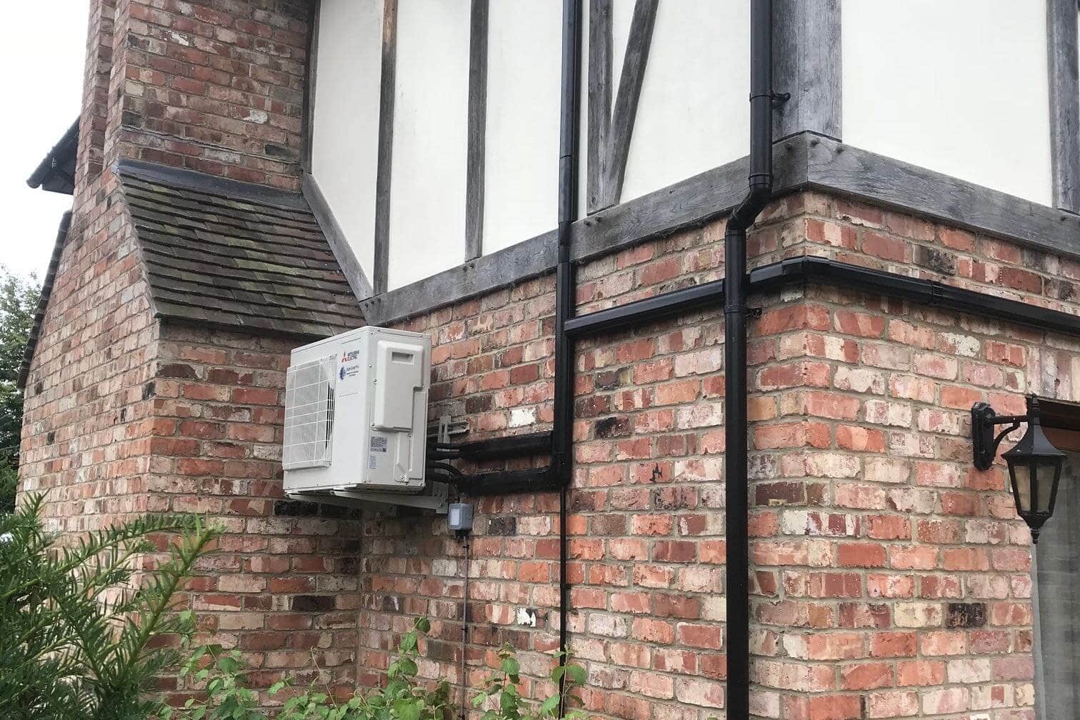 Exterior wall mounted mitsubishi electric domestic air conditioning unit neatly fitted by SubCool FM side view