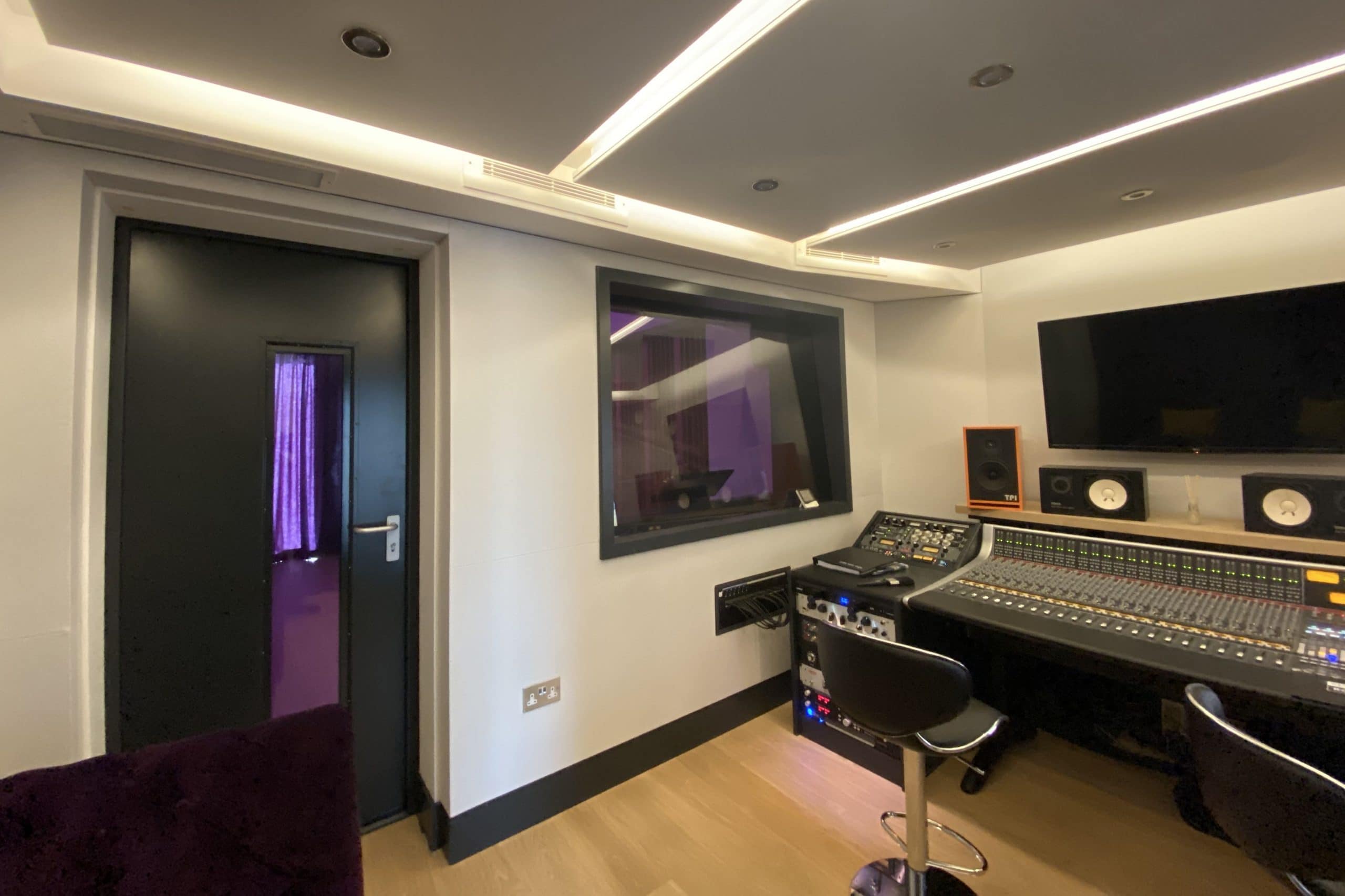 View of multiple white vents of ducted air conditioning system in Arden barn conversion in Lingfield in a music studio over control desk fitted by SubCoolFM
