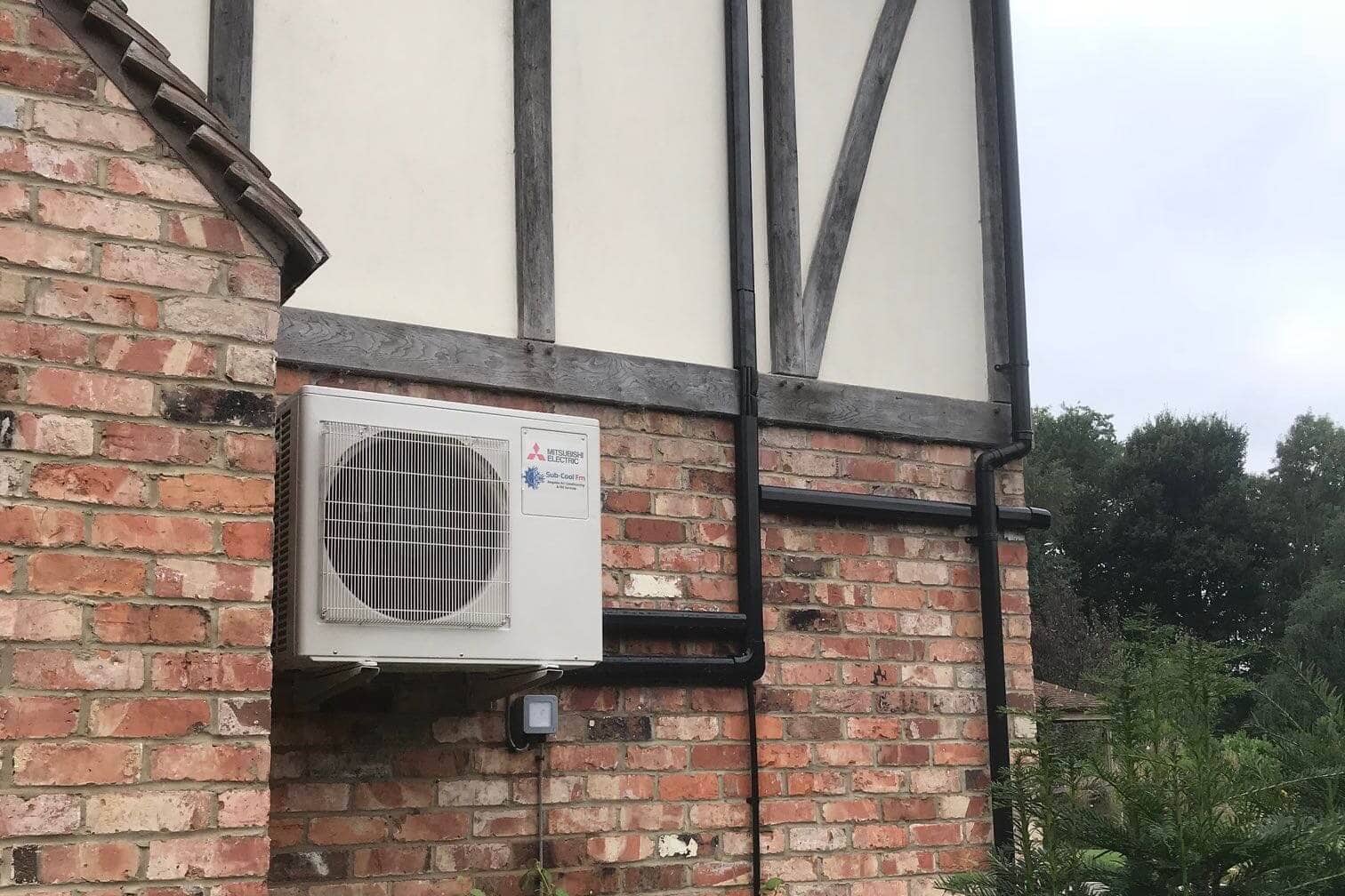 Exterior wall mounted mitsubishi electric domestic air conditioning unit neatly fitted by SubCool FM