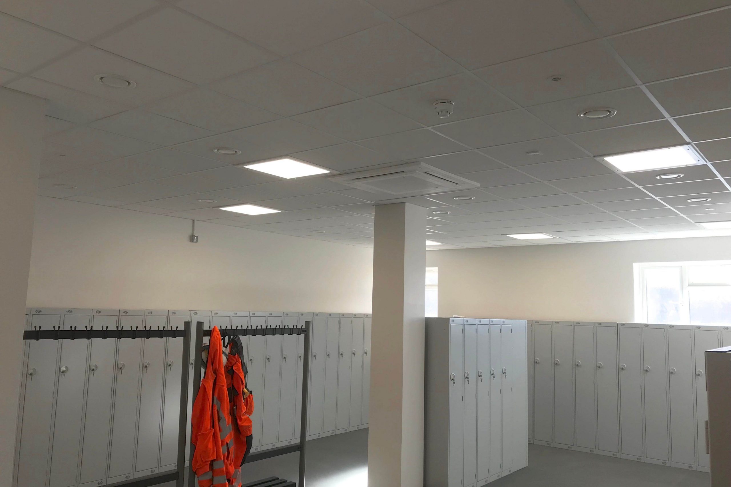 Norwood junction large commercial air conditioning solution by SubCool FM white ceiling cassette unit in locker room