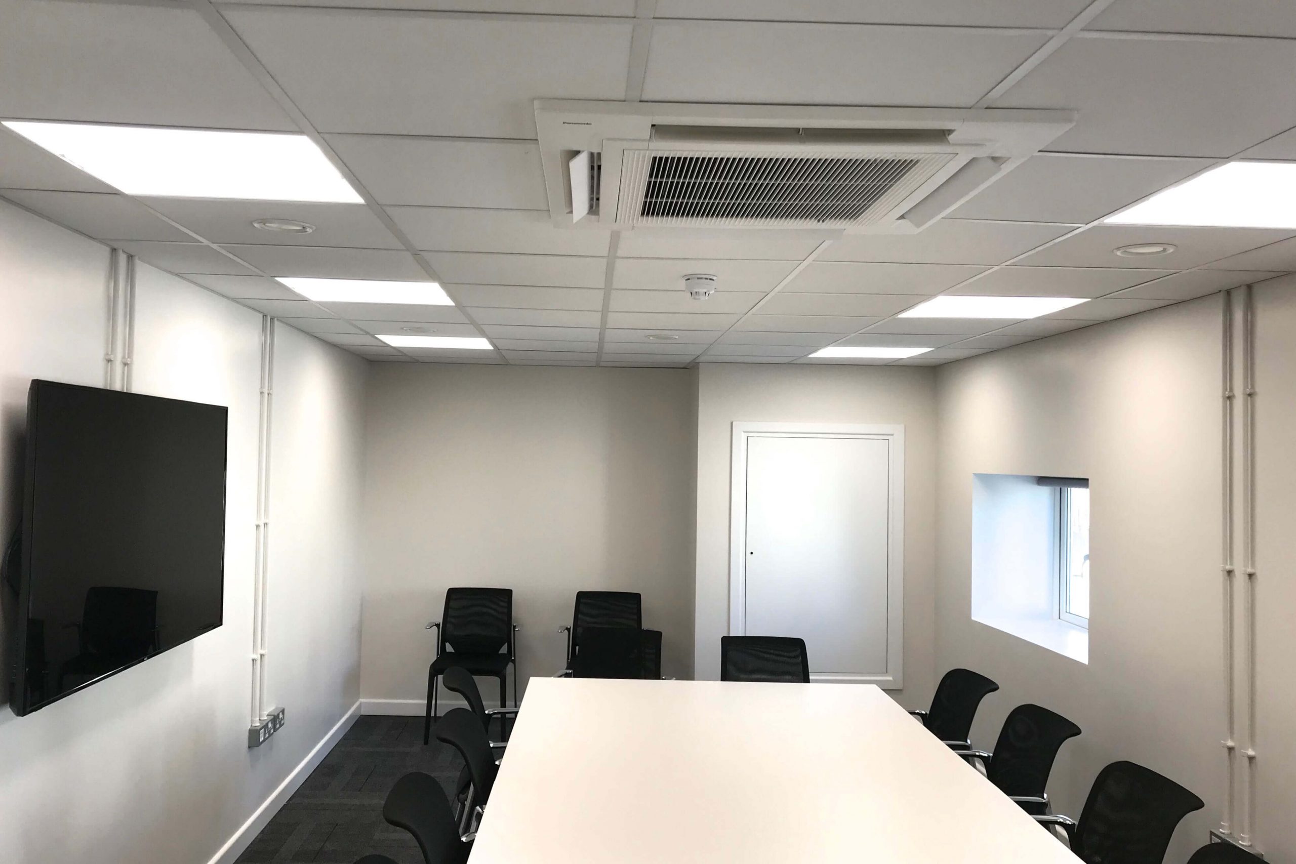 Norwood junction large commercial air conditioning solution by SubCool FM white cassette ceiling unit in meeting room