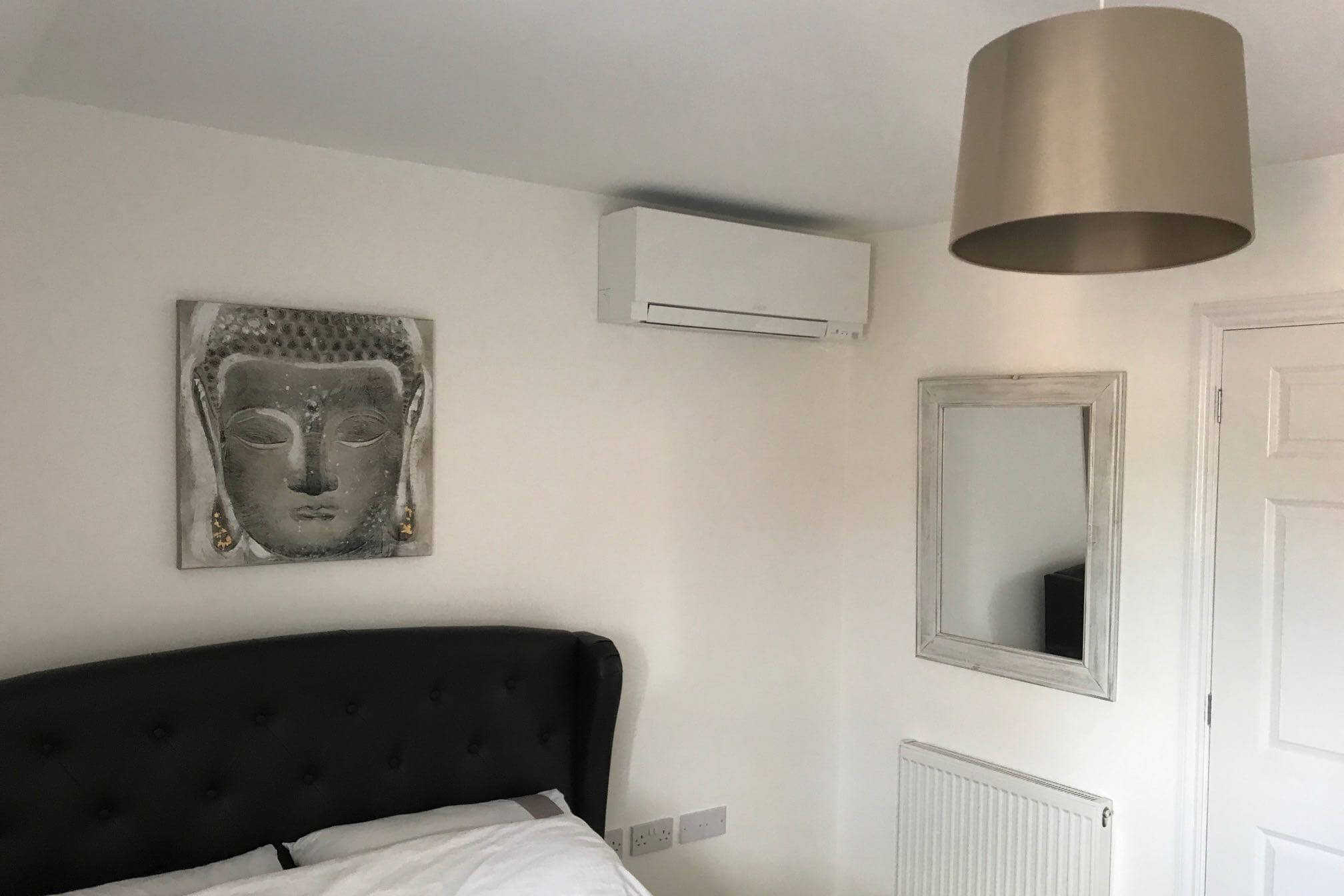 White mall counted mitsubishi domestic air conditioning unit in white and silver bedroom above bed