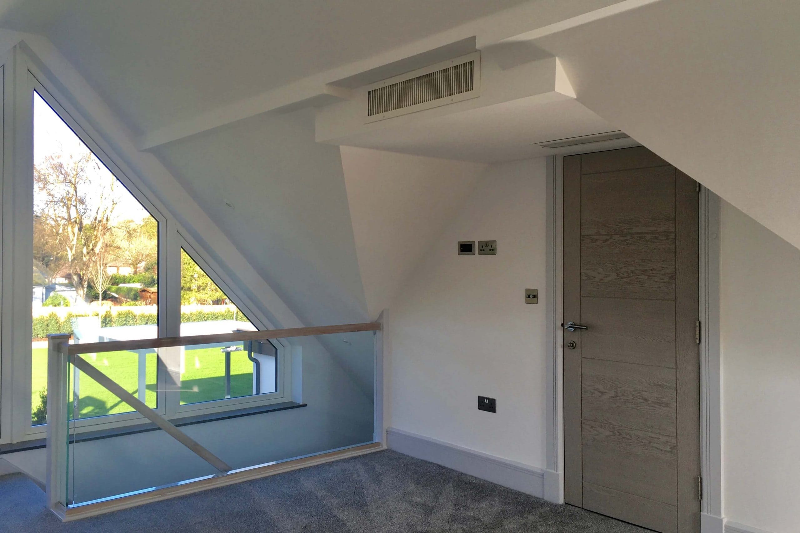 Scandia Hus new build project upstairs bedroom side view with 2 air grills by door as part of MVHR and air conditioning system by SubCool FM