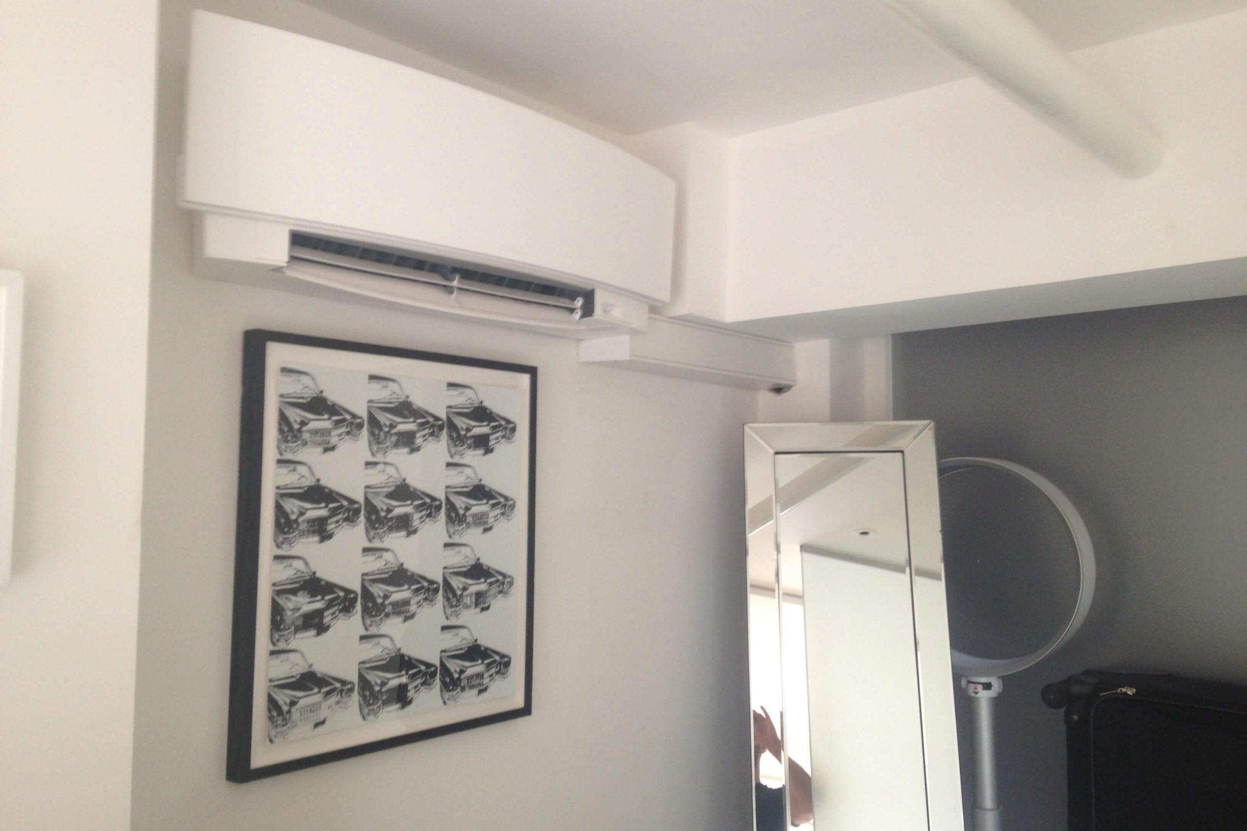 Daikin Emura white wall mounted air conditioning unit above picture in room nook