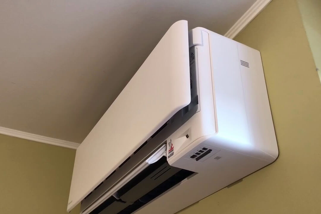 Daikin Stylish white wall mounted air conditioning unit open and in use on yellow walls