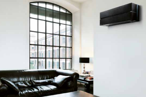 Black Mitsubishi Electric MSZ LN wall mounted air conditioning unit in high ceiling white living room with black sofa