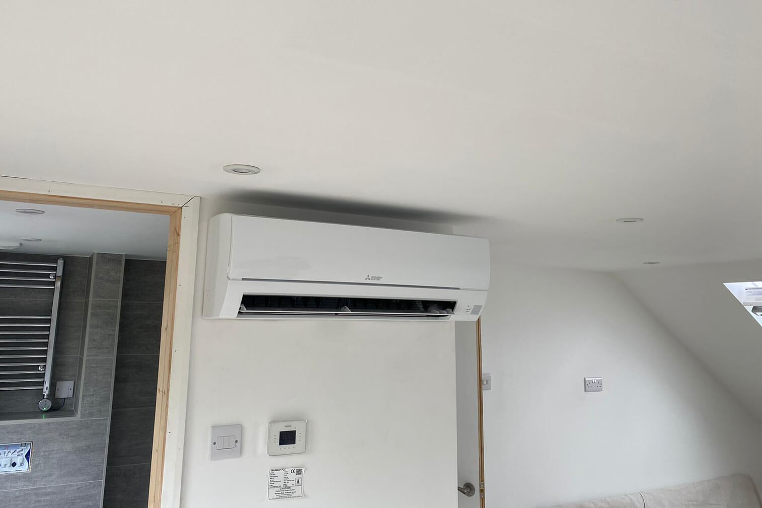 Littlehampton, West Sussex loft conversion with white Mitsubishi Electric wall-mounted air con unit inside by bathroom SubCoolFM