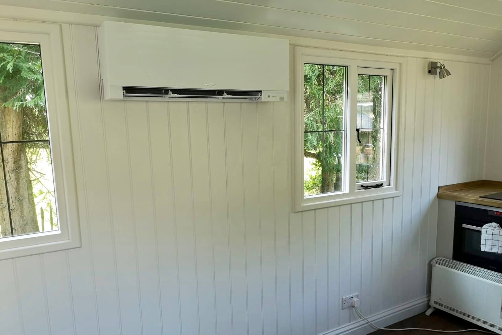 White mitsubishi air conditioning wall mounted unit fitted inside shepherds hut SubCool FM