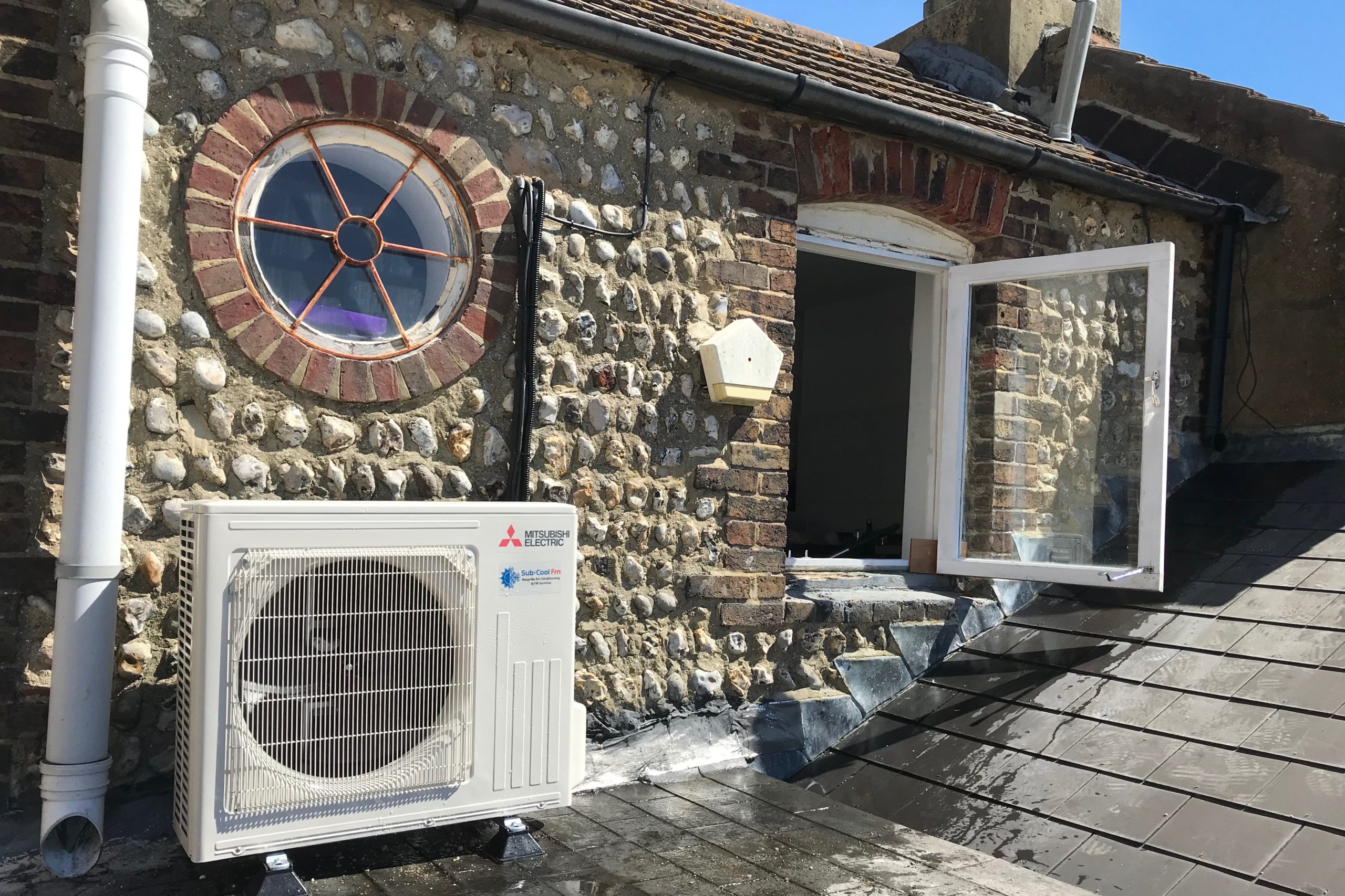 Domestic external Mitsubishi Electric air conditioning unit on upper floor roof