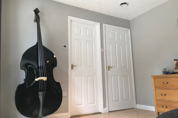 Ceiling duct in room with doors and cello